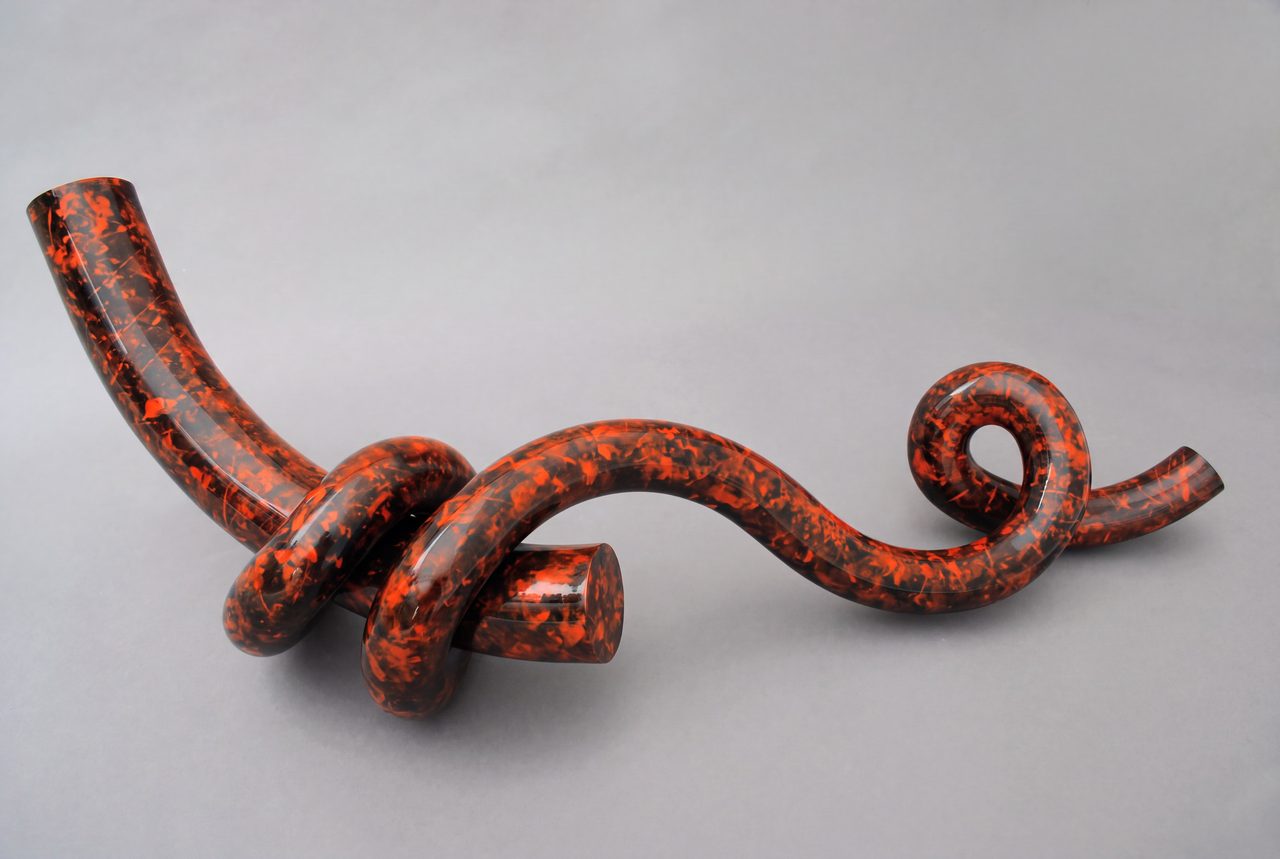 Wrap, a mottled red-and-black painted steel rod knotted around itself with one end curled into a spiral, by David Hamilton