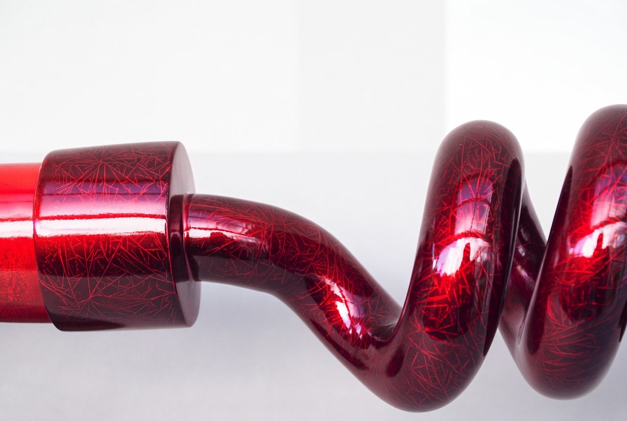Bardiche III, a close view of the glossy red coiled spring section at the centre of the sculpture, by David Hamilton