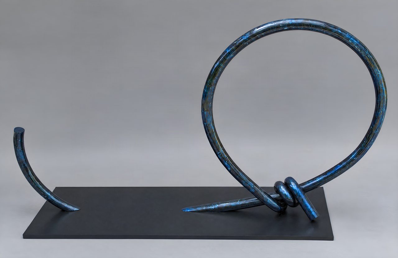 Between, a large blue-green painted steel loop and a short curved spike mounted on a black plinth, by David Hamilton