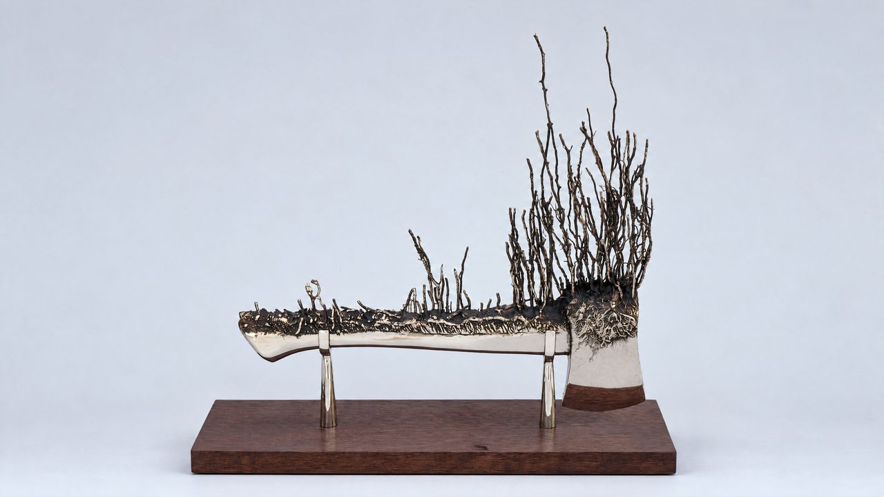 Progression, a bronze axe head sprouting rows of tall thin branches like a burnt hedge, by David Hamilton