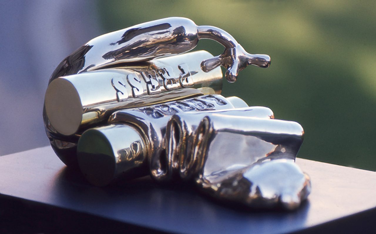 Press, a polished bronze form embossed with the word PRESS beside ridged cylindrical shapes, by David Hamilton