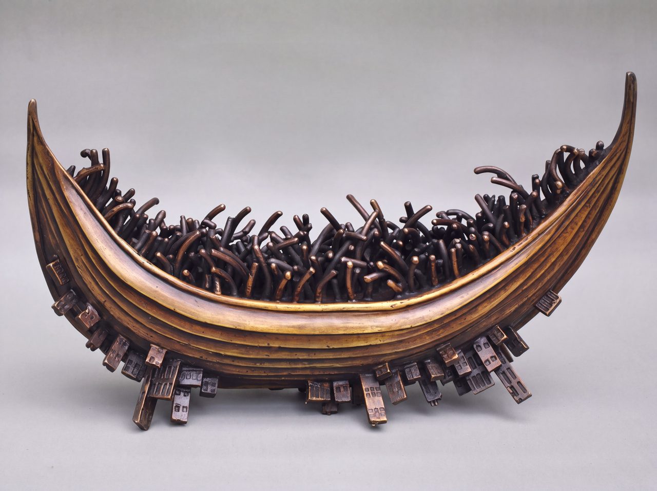 Limpet City, a crescent bronze boat filled with tangled reed-like forms and studded along its hull with tiny limpet-like buildings, by David Hamilton