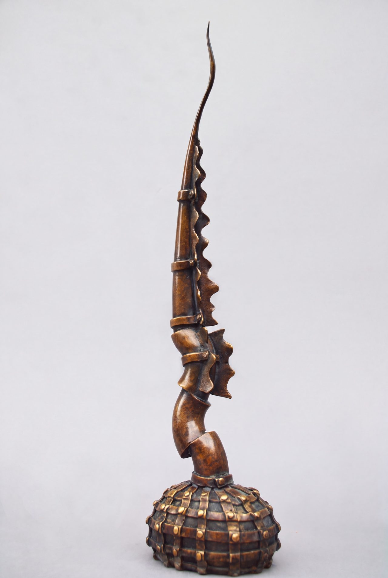 Mace, a tall bronze curved blade banded with rings, rising from a ribbed and studded bulbous base, by David Hamilton