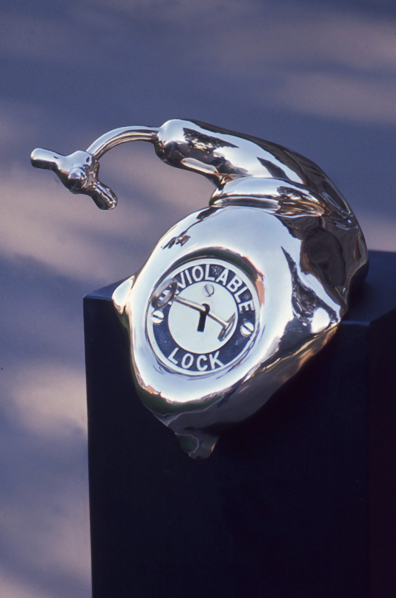 Inviolable lock, a polished bronze form with a keyhole dial embossed INVIOLABLE LOCK, by David Hamilton