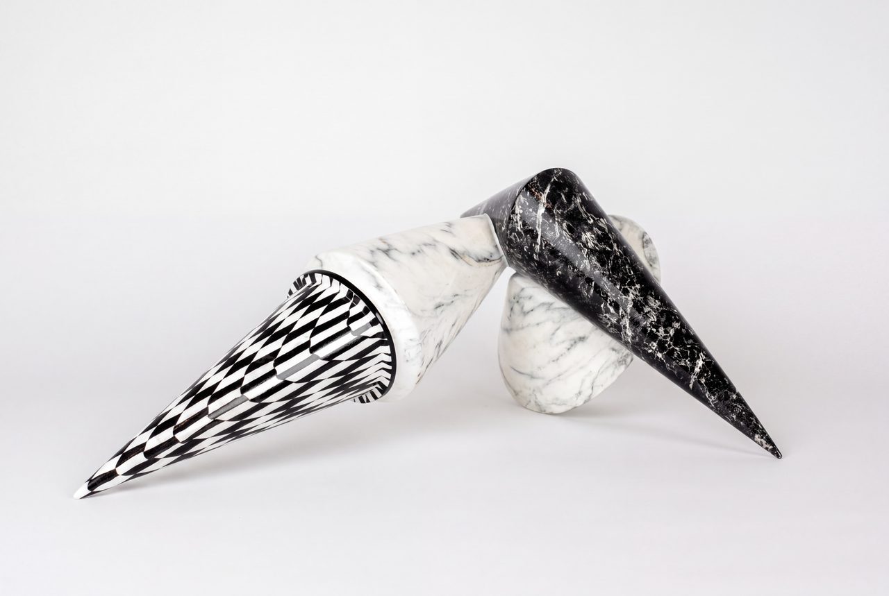 Concurrent Intersections, two marbled cone forms crossing each other, one in black-and-white checkerboard, the other in black marble, by David Hamilton