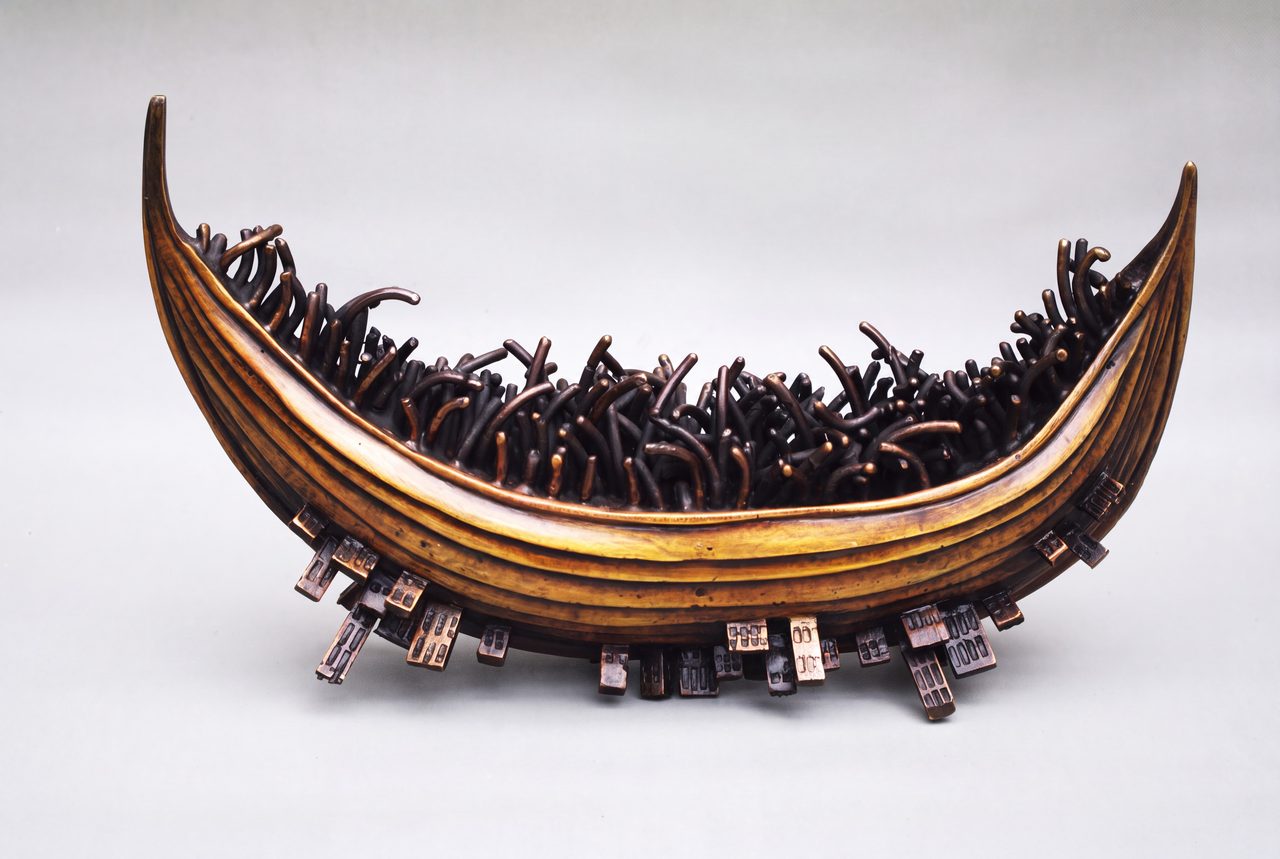 City Reflections, a gold-rimmed bronze boat filled with tangled reed-like forms and tiny buildings along its hull, by David Hamilton