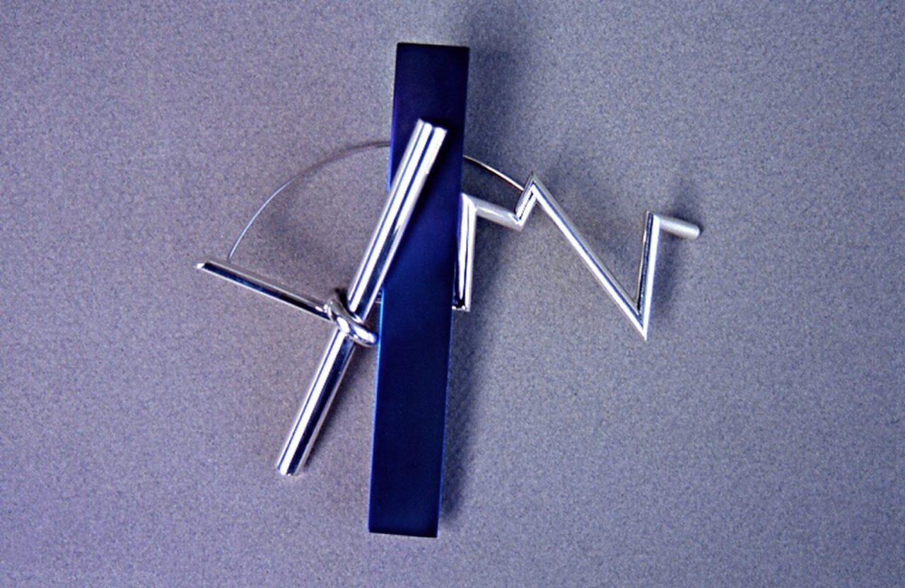 Bolt Discharge, a silver brooch of a zigzag lightning-bolt wire crossed by a dark blue rectangular bar, by David Hamilton