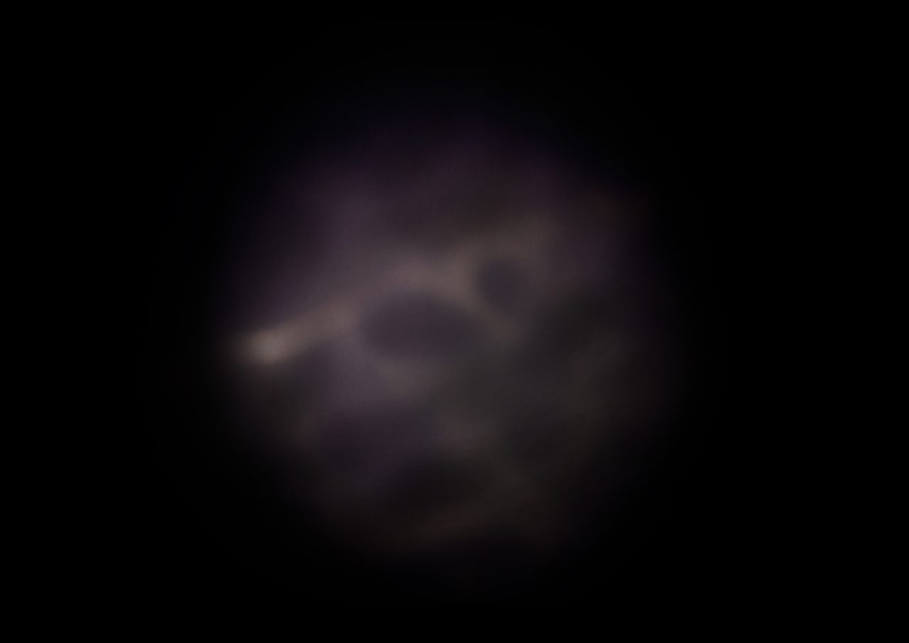 Untitled, an abstract long-exposure photographic study showing a dim purple-brown glow with a curved dark form against black, by David Hamilton