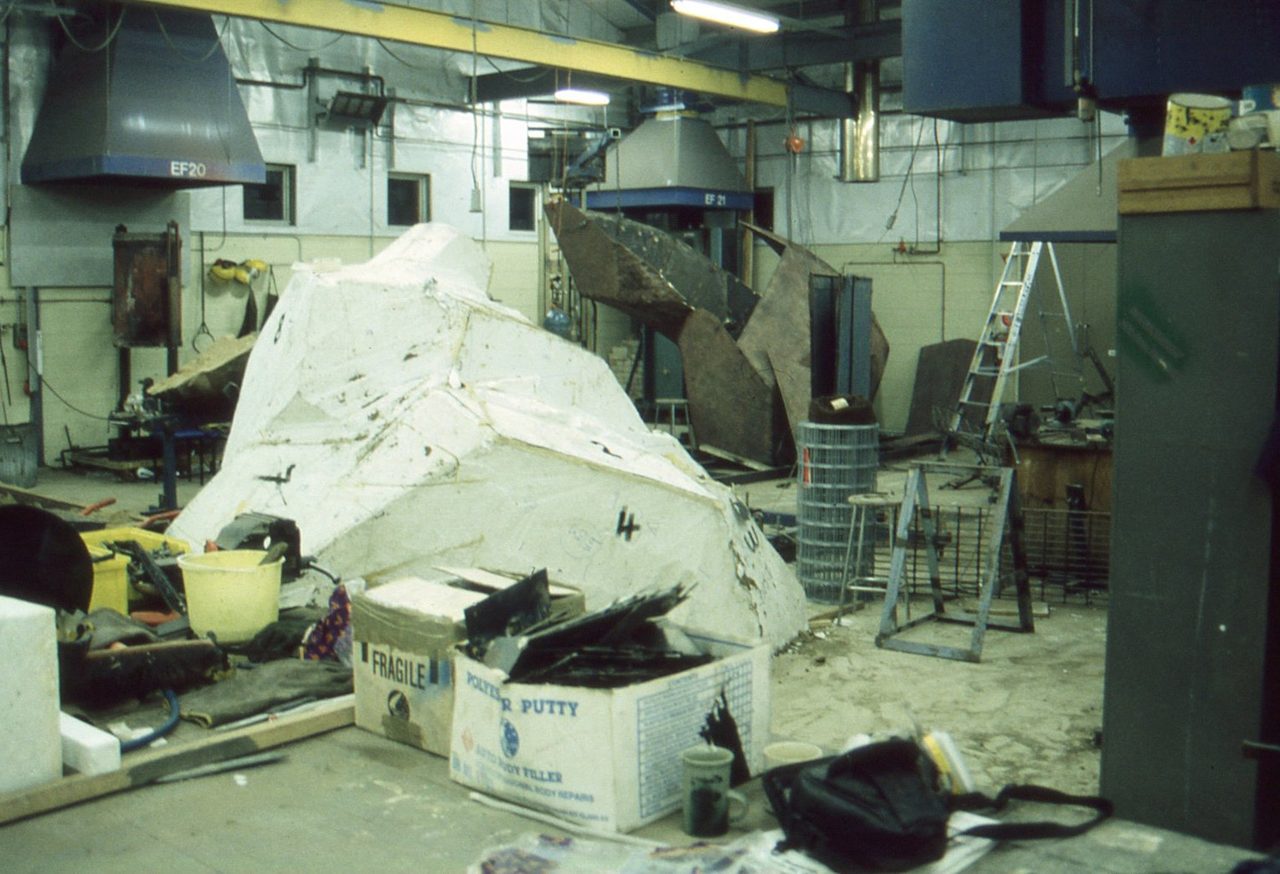 The foam pattern for Overcoming Adversities in the Pilot Art Foundry workshop, wrapped in white, with mould sections behind