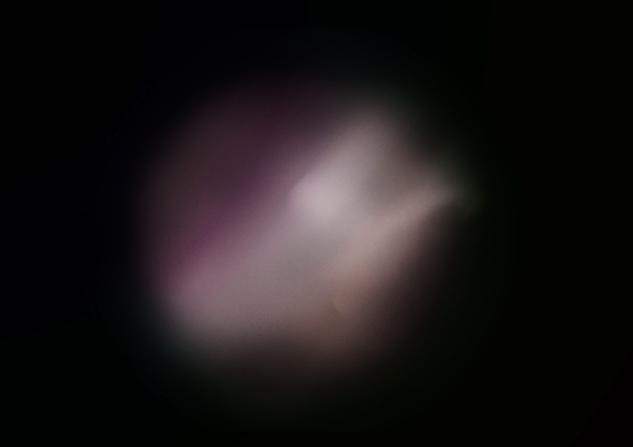 Untitled, an abstract long-exposure photographic study showing a pale figure-like glow tinged pink against black, by David Hamilton