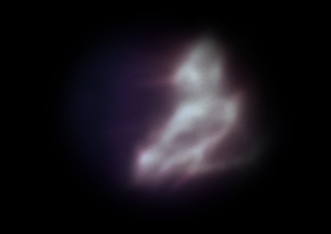 Untitled, an abstract long-exposure photographic study showing a pale white glowing form against black, by David Hamilton