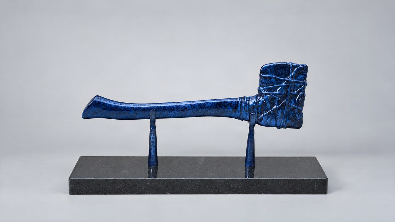 Wrapped Axe, a deep blue mottled axe with a criss-cross banded head, raised on two matching blue stands, by David Hamilton