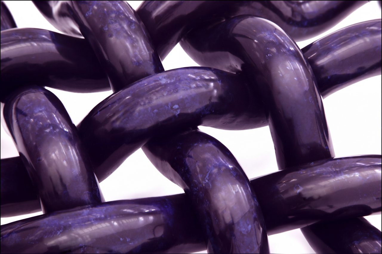 Woven, a close view of the dark blue-black painted steel rods interlocking in a tight woven knot, by David Hamilton