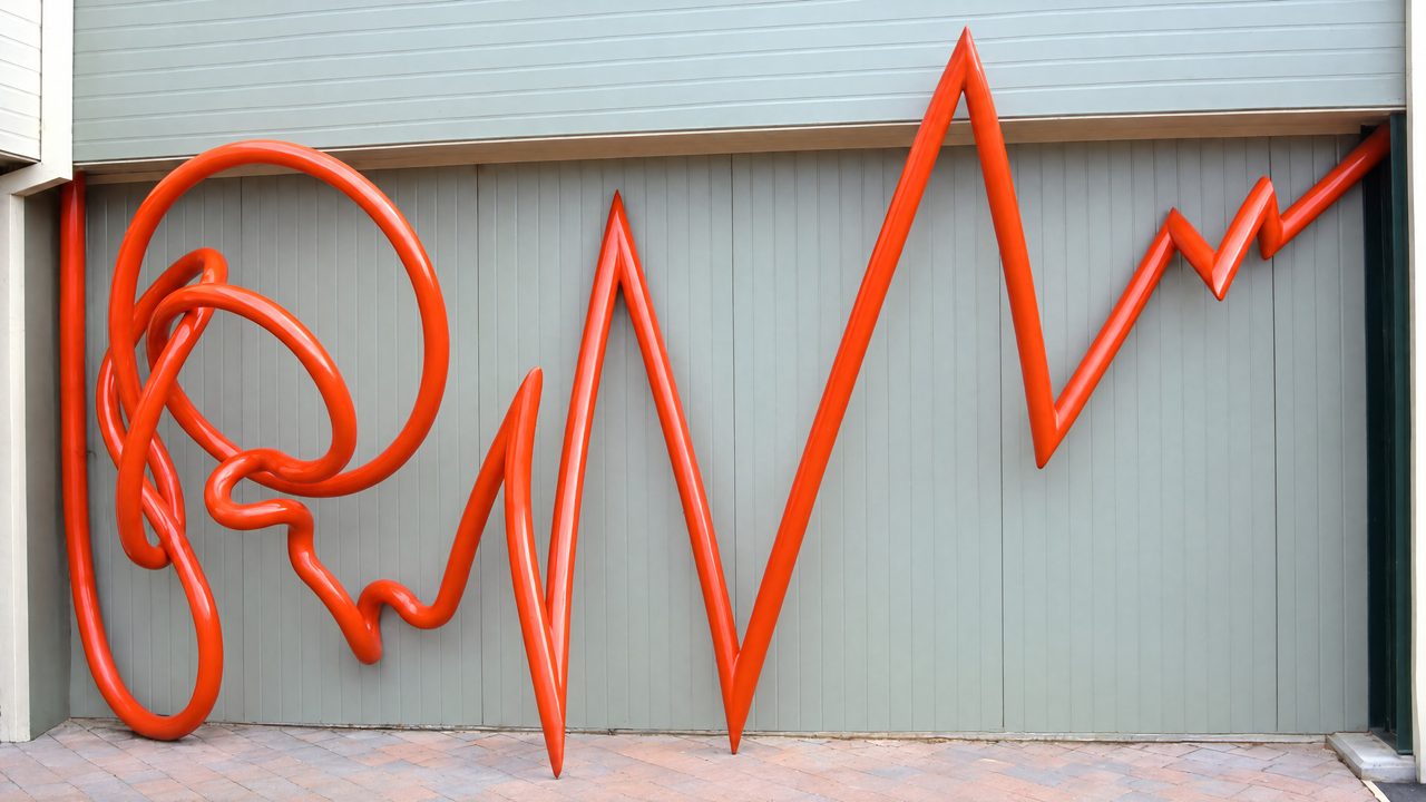 Pulse, a looping and knotted red steel line sculpture that hangs through a window frame at Hellyer College, by David Hamilton