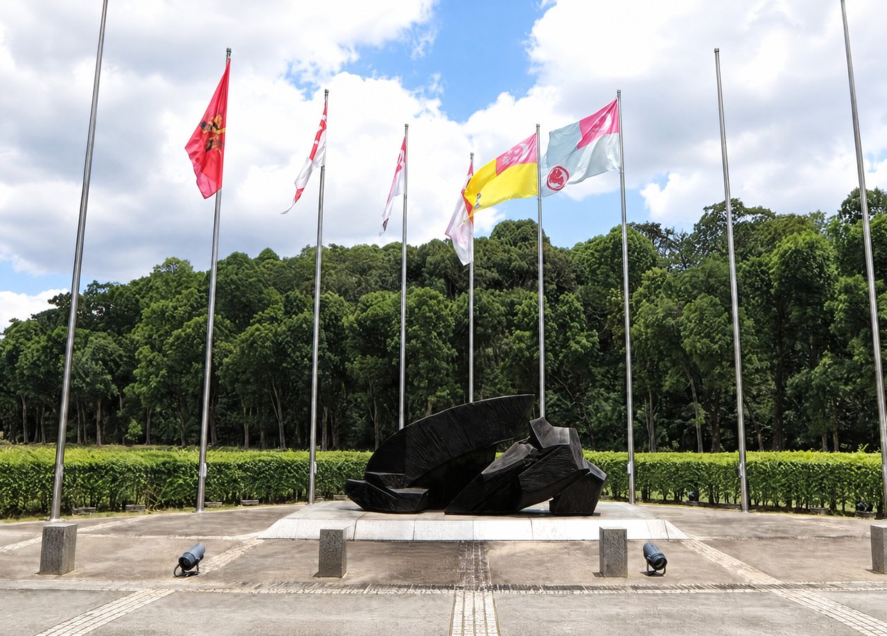 Ju Ming's Overcoming Adversities at the entrance to SAFTI Military Institute, with flagpoles behind it