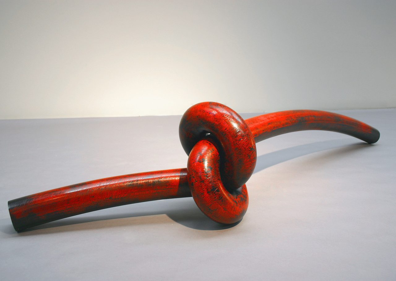 Knot, a mottled red-and-black painted steel rod tied into a single overhand knot, by David Hamilton